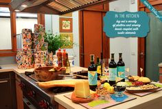 a kitchen counter topped with lots of food and bottles of wine on top of it