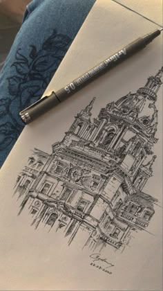 a pen is sitting on top of a piece of paper with a drawing of a building