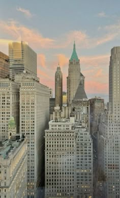 the city skyline is lit up at dusk with many tall buildings in the foreground