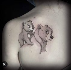 the back of a woman's shoulder with two bears on it and one bear holding another