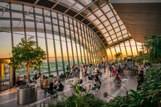 people are sitting and standing in the sky garden at the top of the building