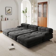 a large black couch sitting on top of a white rug