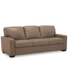 a brown leather couch with two pillows on it's back and one arm facing the camera