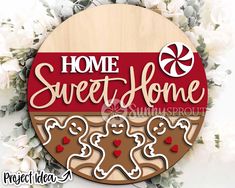 a wooden sign that says home sweet home with gingerbread cookies and candy canes