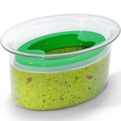 a plastic container filled with green sauce