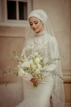 a woman in a wedding dress holding a bouquet