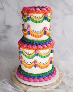 a multi - tiered cake is decorated with colorful icing