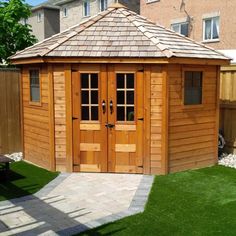 a small wooden shed sitting in the grass