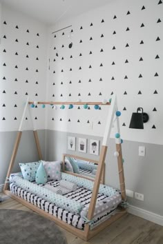 a baby's room with a swing bed and wallpaper