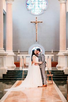 a bride and groom kissing in front of the alter