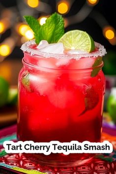 a close up of a drink in a glass with ice and lime on the rim