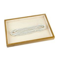 a white beaded necklace in a wooden box