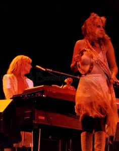 two women are playing instruments on stage