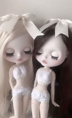 two dolls are sitting next to each other