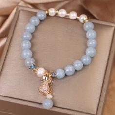 💧 Plongez dans la tranquillité de l'océan avec notre Bracelet Aigue-Marine et Perle – Poche d'Argent. Ce bijou sublime est composé de perles d'aigue-marine, rappelant les profondeurs apaisantes de la mer, et de perles blanches naturelles, symboles de pureté et d'élégance.  💰 Au centre, un pendentif unique en forme de poche d'argent renferme une perle blanche, symbolisant la fortune et l'abondance.  🌊 L'aigue-marine, connue pour ses vertus d'apaisement et de courage, complète parfaitement la d Money Pouch, Lucky Stone, Trendy Bracelets, Aquamarine Beads, Stitch Fix Stylist, Aquamarine Crystal, Money Bag, Girly Jewelry, Positive Change