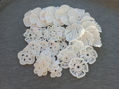 several white crocheted flowers on a gray surface