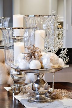 a tray with candles, ornaments and other items on it sitting on a dining room table