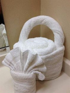 a white basket sitting on top of a bathroom counter