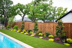 a backyard with a pool and fenced in lawn area next to the swimming pool