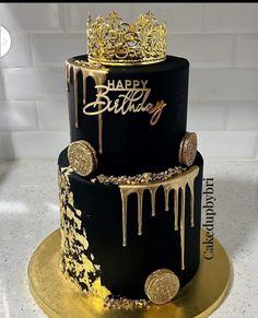 a black and gold birthday cake with dripping icing