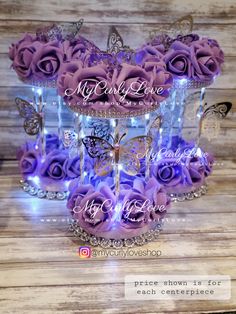 three tiered cake with purple roses and butterflies on the top, surrounded by crystals