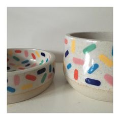 two bowls with different designs on them sitting next to each other