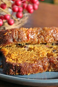 two slices of fruitcake on a plate with berries in the backgroung