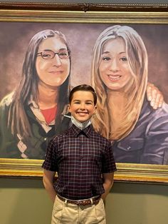 a boy standing in front of a portrait of two women