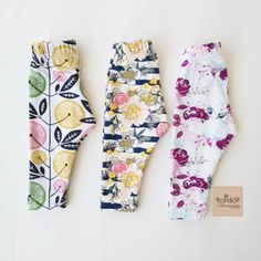 three baby leggings are lined up next to each other on a white surface