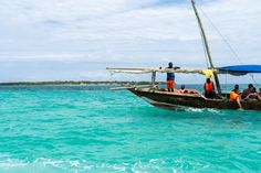 people are riding on the back of a boat in the ocean