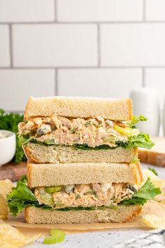 two sandwiches stacked on top of each other with lettuce and chicken in the middle