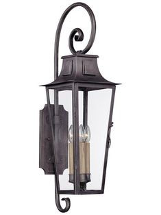 an outdoor wall light with two candles on it