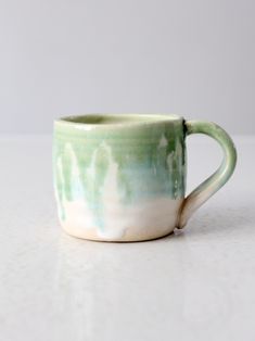 a green and white cup sitting on top of a table