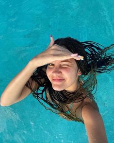 a woman standing in the water with her hands on her head