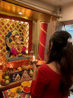 a woman in red shirt standing next to an idol