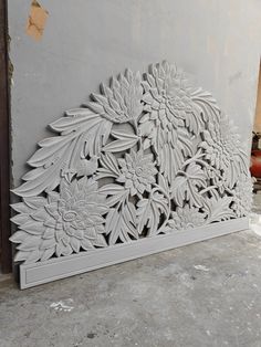 an intricately carved wall panel with flowers and leaves on the outside, is shown