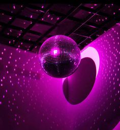 a disco ball hanging from the ceiling in front of a wall with stars on it