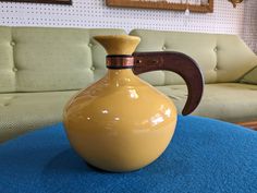 a yellow vase sitting on top of a blue ottoman