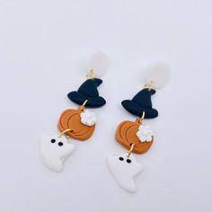 two pairs of earrings with white, orange and blue shapes