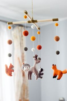 a mobile phone with an image of animals hanging from it's sides and the text, needle felt baby mobile forest animal, woodland baby crib mobile nursery decor