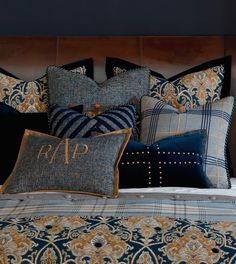 a bed topped with lots of pillows next to a night stand