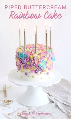 there is a cake with candles on it and the words pipped buttercream rainbow cake