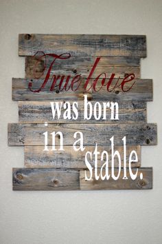 a wooden sign that says true love was born in a stable, on the wall