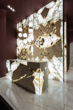 a marble counter top with lights hanging from it's sides and an apple logo on the wall