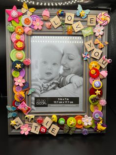 a photo frame decorated with buttons and letters