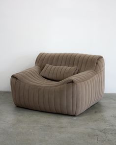 a brown couch sitting on top of a cement floor