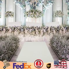 an image of a wedding ceremony with flowers on the wall and white carpeted aisle