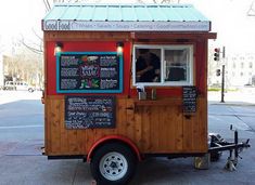 a small food truck is parked on the side of the road