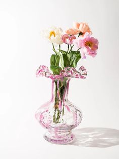 a glass vase filled with pink and white flowers