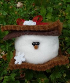 a snowman ornament hanging from a tree